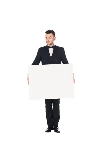 Homem elegante bonito em terno preto posando com cartaz em branco isolado no branco — Fotografia de Stock