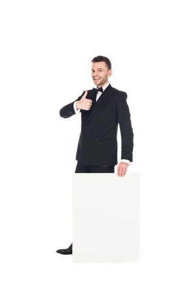 Schöner eleganter Mann mit leerem Plakat, das den Daumen vereinzelt auf weiß zeigt — Stockfoto