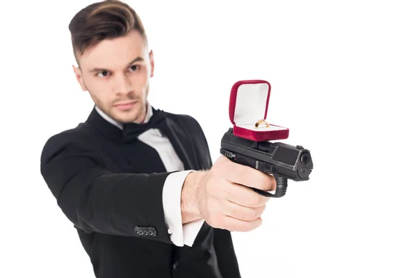 Tueur masculin en costume noir visant avec arme à feu avec bague de demande en mariage, isolé sur blanc — Photo de stock