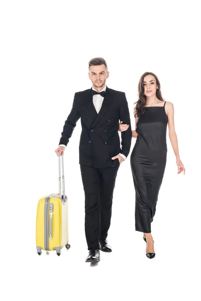 Beautiful elegant couple in black clothes walking with travel bags, isolated on white — Stock Photo