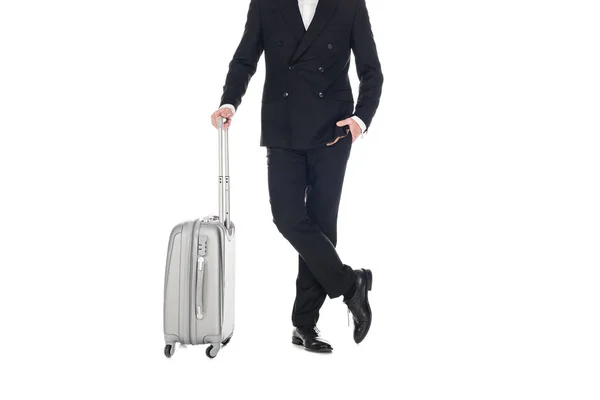 Vue recadrée de l'homme élégant en smoking noir posant avec sac de voyage isolé sur blanc — Photo de stock