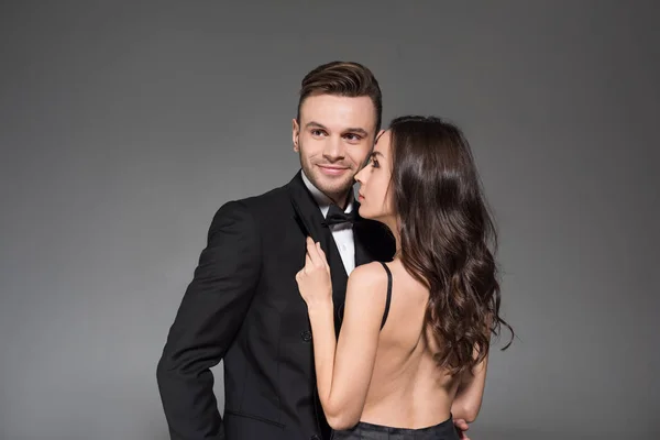 Feliz belo casal elegante em roupas pretas abraçando isolado no cinza — Fotografia de Stock