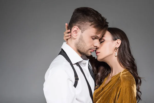 Schönes zartes Paar küsst isoliert auf grau — Stockfoto