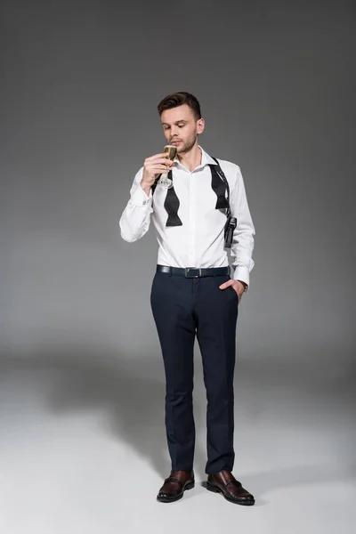 Homem bonito em camisa branca bebendo champanhe em cinza — Fotografia de Stock