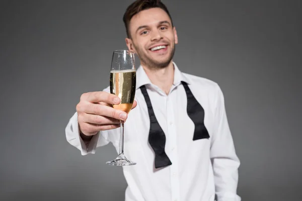 Bell'uomo allegro brindare con bicchiere di champagne isolato su grigio — Foto stock