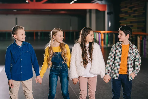 Bunt gekleidete Kinderschar, die sich an den Händen hält und einander ansieht — Stockfoto