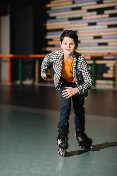 Selective focus of cute smiling boy skating on rollers — Stock Photo