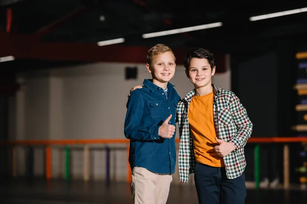 Enfoque selectivo de niños sonrientes felices mostrando pulgares hacia arriba - foto de stock