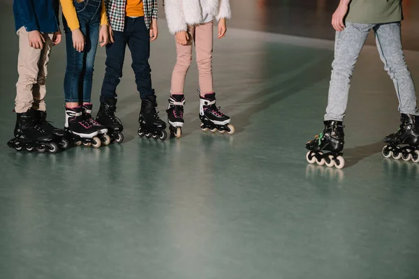 Partial view of children in roller skates listening to trainer instructions — Stock Photo