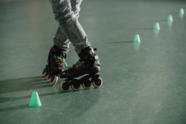 Vista recortada de las piernas de los niños en patines sobre ruedas en posición especial - foto de stock