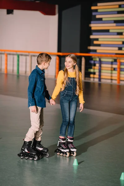 Beautiful smiling skating and holding hands — Stock Photo