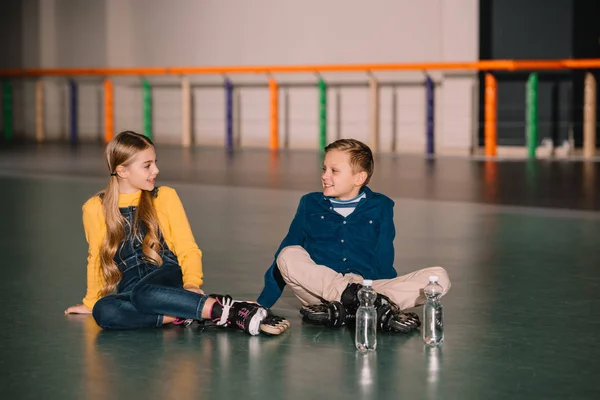 Niedliche Kinder ruhen sich nach dem Skaten mit Rollschuhen aus — Stockfoto