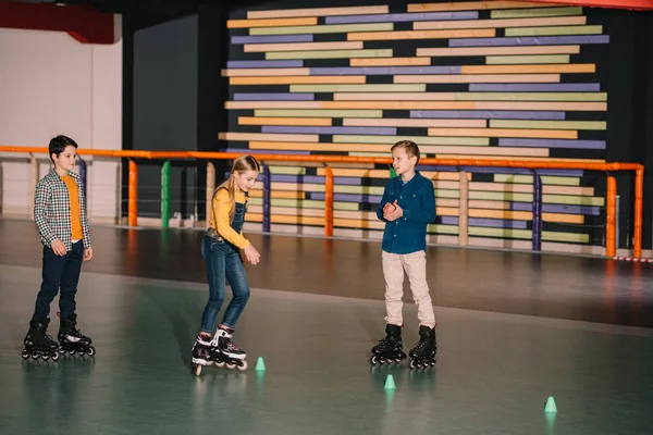 Jugendliche Rollschuhfahrer üben gemeinsam Schlittschuhlaufen auf Eisbahn — Stockfoto