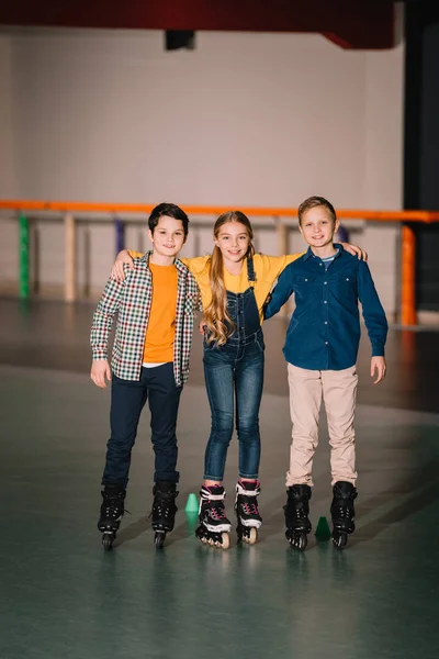 Plan complet de câlins souriants pour enfants sur la patinoire — Photo de stock