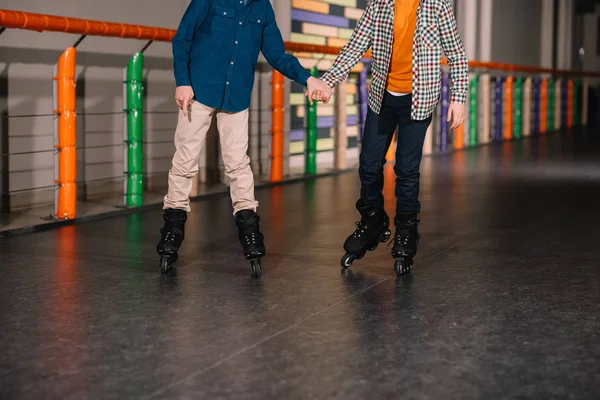Cropped view of preteen roller skaters holding hands — Stock Photo