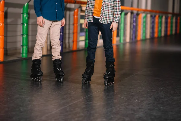 Vista parcial de meninos em patins pretos posando na pista — Fotografia de Stock