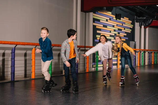 Сміються діти в роликових ковзанах насолоджуючись дозвіллям — стокове фото