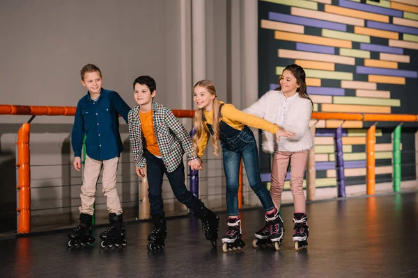 Tiro de longitud completa de los niños tonteando en pista de patinaje — Stock Photo