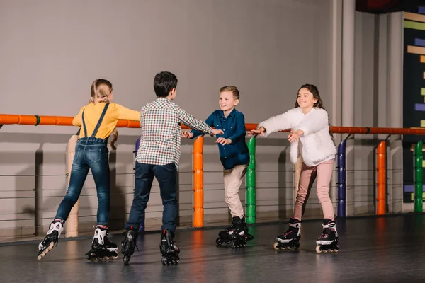 Grupo de niños jugando en la pista de patinaje - foto de stock