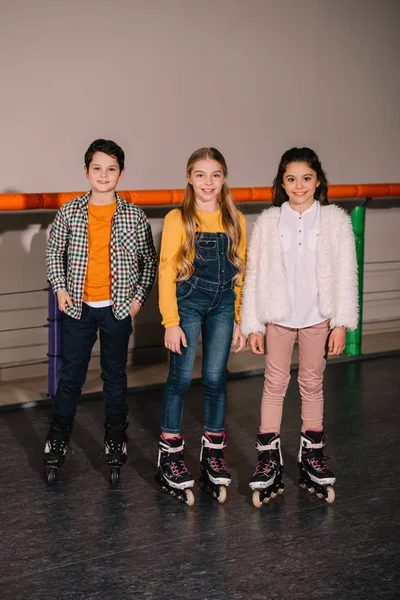 Colpo pieno di bambini felici che si esercitano sulla pista di pattinaggio — Foto stock