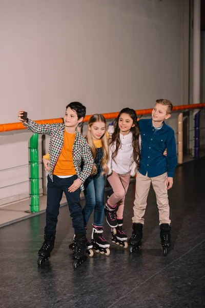 KIds in pattini a rotelle facendo selfie dopo l'allenamento sulla pista di pattinaggio — Foto stock