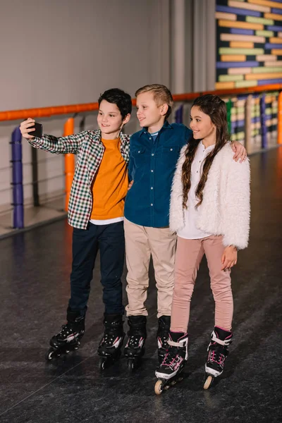 Kids hugs on roller rink and making selfie — Stock Photo