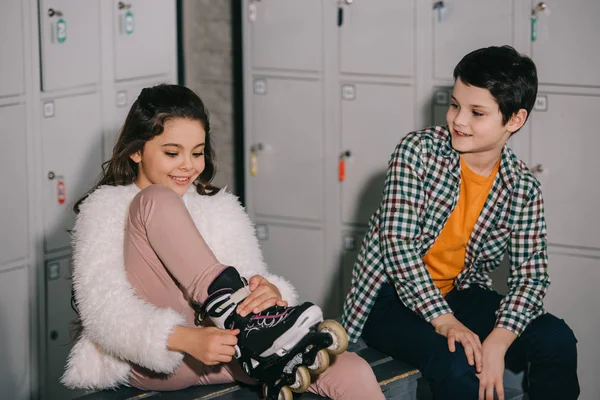 Kinder reden und ziehen Rollschuhe aus — Stockfoto