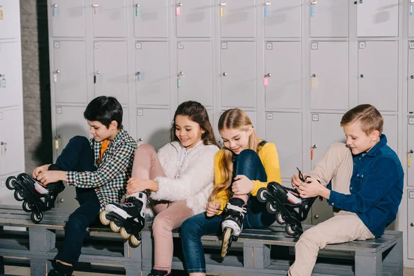 Cute kids smiling and putting on roller skates — Stock Photo