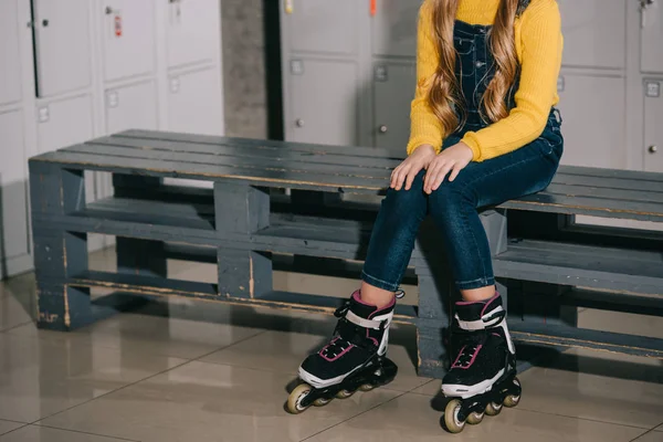 Vista recortada del niño con el pelo largo posando en patines - foto de stock