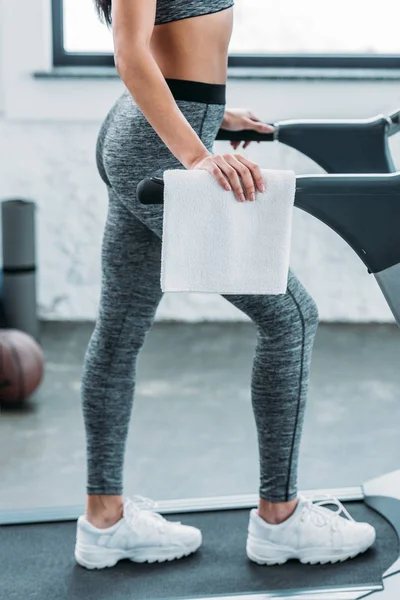 Section basse de fille afro-américaine en vêtements de sport exercice sur tapis roulant dans la salle de gym — Photo de stock