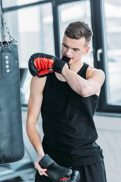Спортивний молодий спортсмен в боксерській рукавичці з зубами в спортзалі — стокове фото