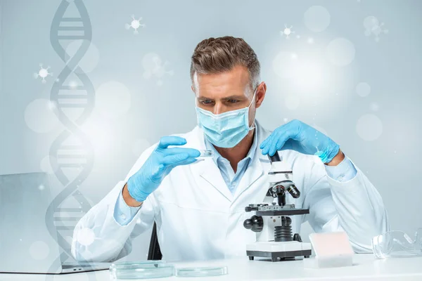 Schöner Wissenschaftler in medizinischer Maske und medizinischen Handschuhen, der mit dna experimentiert — Stockfoto