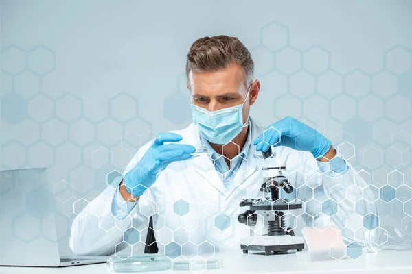 Gut aussehender Wissenschaftler in medizinischer Maske und medizinischen Handschuhen macht Experiment — Stockfoto