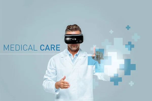 Scientist in virtual reality headset touching medical care interface isolated on grey, artificial intelligence concept — Stock Photo