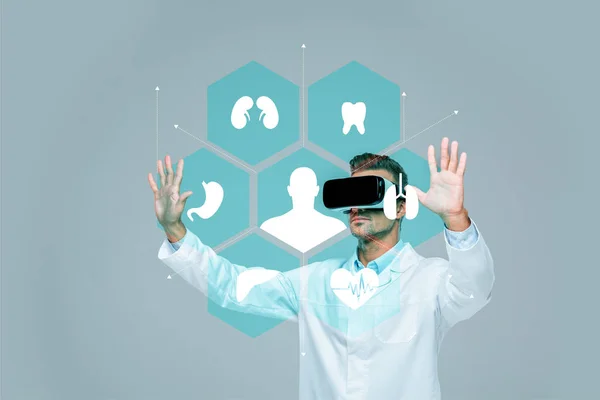 Scientist in virtual reality headset touching medical interface in air isolated on grey, artificial intelligence concept — Stock Photo