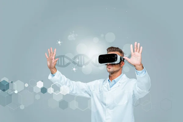 Scientist in virtual reality headset touching dna interface in air isolated on grey, artificial intelligence concept — Stock Photo