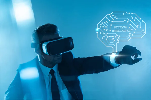 Businessman in virtual reality headset with brain isolated on blue, artificial intelligence concept — Stock Photo