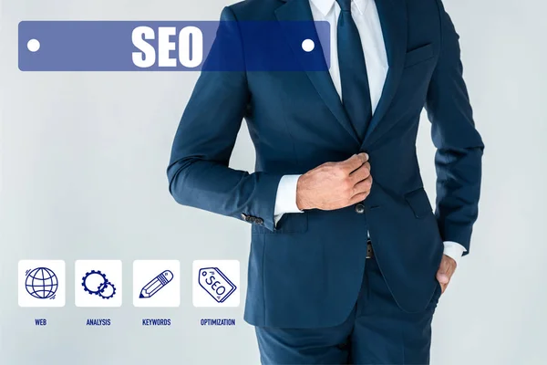 Cropped image of businessman buttoning jacket isolated on white with seo icons — Stock Photo
