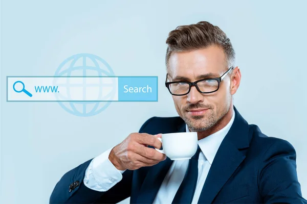 Handsome businessman drinking coffee and looking at camera isolated on blue with search bar — Stock Photo