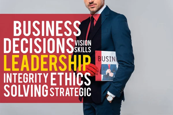 Cropped image of businessman holding newspaper isolated on grey with leadership lettering — Stock Photo