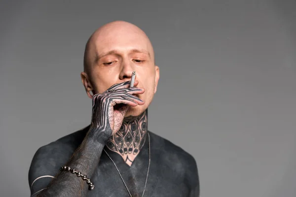 Bald shirtless tattooed man smoking cigarette isolated on grey — Stock Photo
