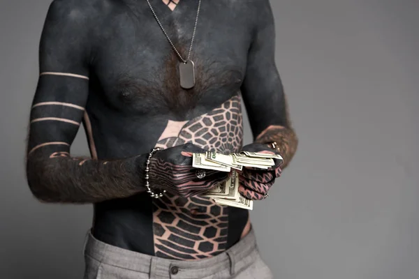 Plan recadré d'homme à poitrine nue avec des tatouages comptant l'argent isolé sur gris — Photo de stock