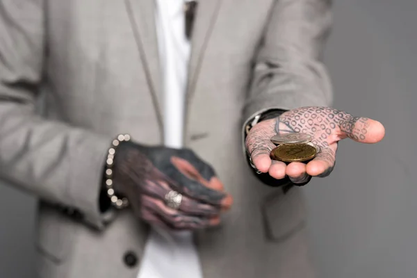 Close-up view of tattooed man holding bitcoins isolated on grey — Stock Photo
