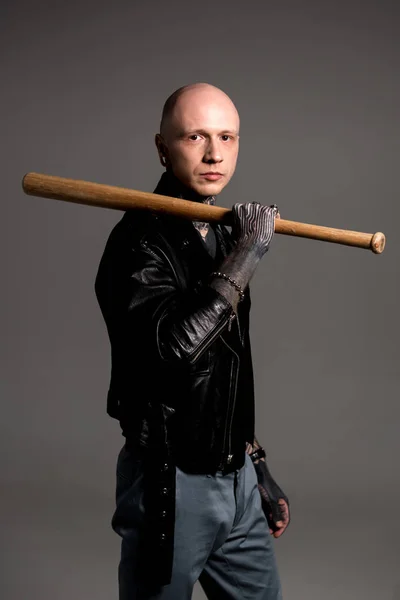 Stylischer glatzköpfiger Mann mit Tätowierungen, Baseballschläger in der Hand und Blick in die Kamera isoliert auf grau — Stockfoto