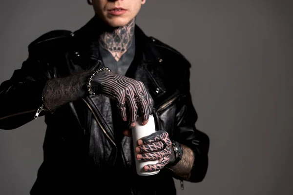Cropped shot of tattooed man in leather jacket opening soda can isolated on grey — Stock Photo