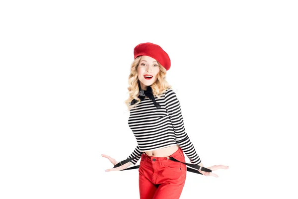 Smiling woman in red beret holding suspenders isolated on white — Stock Photo