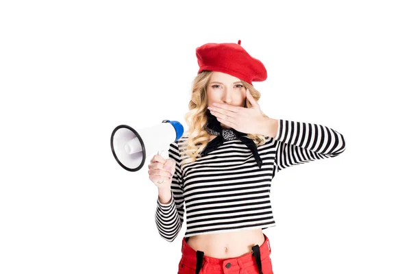 Woman in red beret holding hand on lips and megaphone isolated on white — Stock Photo