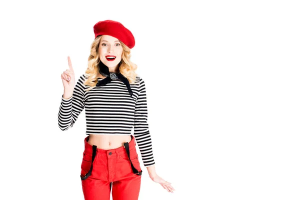 Frau in roter Baskenmütze hält Finger in die Höhe, während sie Idee isoliert auf weiß hat — Stockfoto