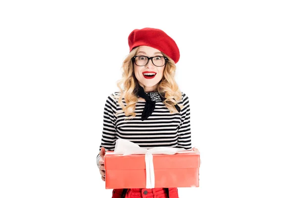 Cheerful blonde woman in red beret holding gift box isolated on white — Stock Photo