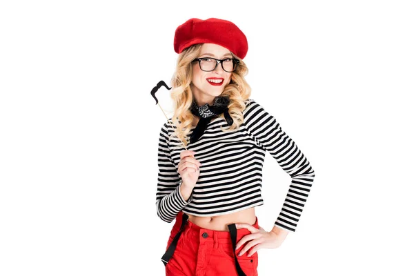 Femme blonde gaie dans des lunettes tenant fausse moustache sur bâton isolé sur blanc — Photo de stock